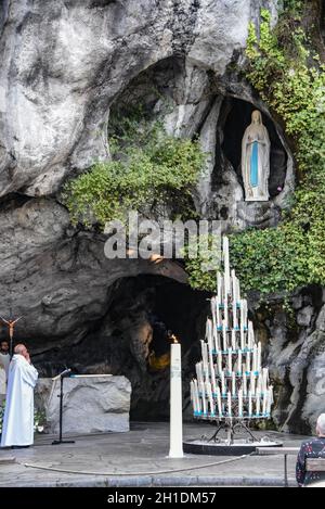 Lourdes, Frankreich - 9. Oktober 2021: Katholische Pilger nehmen an einem Gottesdienst in der Grotte Massabielle in der Rosenkranzbasilika von Lourdes Teil Stockfoto