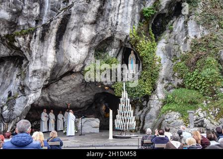 Lourdes, Frankreich - 9. Oktober 2021: Katholische Pilger nehmen an einem Gottesdienst in der Grotte Massabielle in der Rosenkranzbasilika von Lourdes Teil Stockfoto