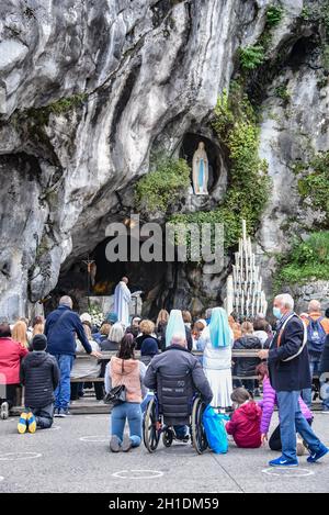 Lourdes, Frankreich - 9. Oktober 2021: Katholische Pilger nehmen an einem Gottesdienst in der Grotte Massabielle in der Rosenkranzbasilika von Lourdes Teil Stockfoto