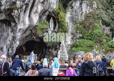 Lourdes, Frankreich - 9. Oktober 2021: Katholische Pilger nehmen an einem Gottesdienst in der Grotte Massabielle in der Rosenkranzbasilika von Lourdes Teil Stockfoto