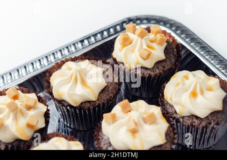 Gesalzene Karamell-Cupcakes, verführerische kleine Schokolade Cupcakes mit einem Baileys Geschmack Zuckerguss und Karamell Nieselregen, Süßigkeiten Stockfoto