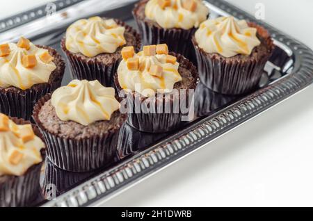 Gesalzene Karamell-Cupcakes, verführerische kleine Schokolade Cupcakes mit einem Baileys Geschmack Zuckerguss und Karamell Nieselregen, Süßigkeiten Stockfoto