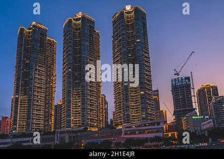 Chongqing, China - August 2019 : Nachtsicht auf die modernen Geschäfts- und Geschäftsgebäude am Flussufer bei Dämmerung Stockfoto