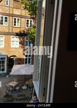 LUENBURG, NIEDERSACHSEN, DEUTSCHLAND - 28. JULI 2018: Luenburg - 27. Juli 2018: Blick vom Hotelfenster auf einen kleinen Marktplatz und eine Kaffeeröstung Stockfoto