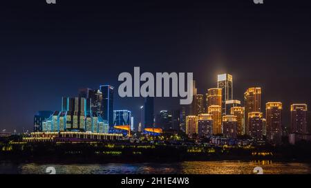 Chongqing, China - August 2019 : Nachtsicht auf die Stadt Chongqing beleuchtet Jialing und Yangtze mit beleuchteten Wolkenkratzern im Hintergrund Stockfoto