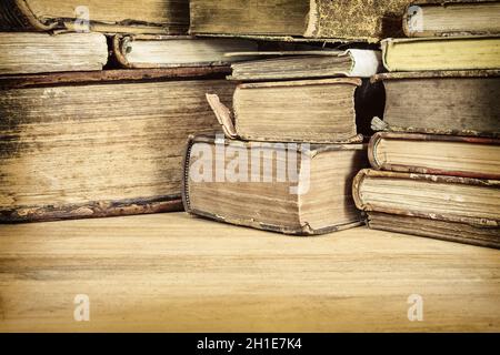 Sepiafarbtes Bild von alten Büchern auf einem Holztisch Stockfoto