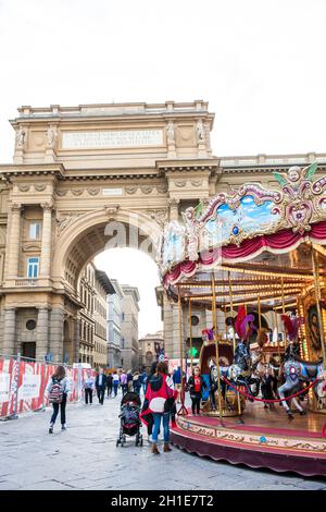 Florenz, Italien - April, 2018: Touristen und Einheimische am Platz der Republik neben dem Karussell und der Triumphbogen in einem frühen Frühling Stockfoto