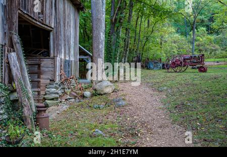 Antiker Farmall F-14 Traktor in der Nähe von Stall in Ely's Mill entlang des Roaring Fork Motor Nature Trail im Great Smoky Mountains National Park Stockfoto