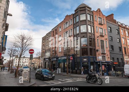 Dublin, Irland - 16. Februar 2019: Menschen, die an einem Wintertag eine kleine Straße mit typischer Architektur der kleinen Innenstadt entlang gehen Stockfoto