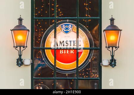 AMSTERDAM, NIEDERLANDE - 16. MAI 2014: Beleuchtetes Schild mit dem niederländischen Amstel Beer-Logo hinter einem Fenster eines alten Amsterdamer Pubs Stockfoto