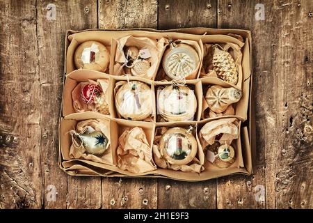 Retro-Stil Bild von vintage Weihnachtsdekoration in einer Box auf einem Holzboden Stockfoto