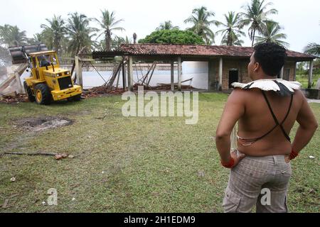 ilheus, bahia / brasilien - 1. februar 2012: Tupinamba Indian beobachtet, wie eine Maschine Haus zerstört, nachdem die Justiz den Haftbefehl für die Wiederinbesitznahme der Farm erfüllt hat Stockfoto