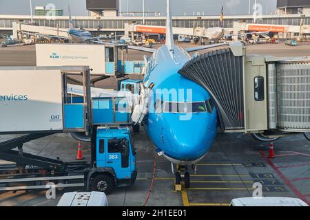 AMSTERDAM, NIEDERLANDE - UM 2019: KLM-Linienflugzeug wird am internationalen Flughafen Amsterdam Schiphol mit Catering-Lieferungen von LKWs verladen Stockfoto