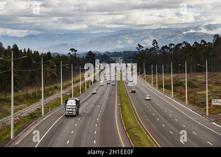 COTOPAXI, ECUADOR - 10. MAI 2019: Verkehr auf dem Panamerikanischen Highway, Ausfahrt zum Cotopaxi National Park, einem beliebten Touristenort Stockfoto