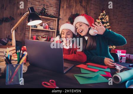 Portrait von fröhlichen Freunden Vorbereitung der Veranstaltung Schaffung Adventsatmosphäre noel mit Laptop ruft winken Hallo im Loft zu Hause drinnen Stockfoto