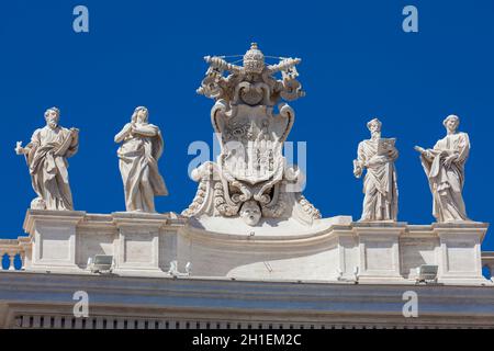 Detail der Chigi Wappen und die Statuen der Heiligen, die Krone der Kolonnaden von St. Peter Platz 1667 auf den Vatikan Stadt gebaut Stockfoto