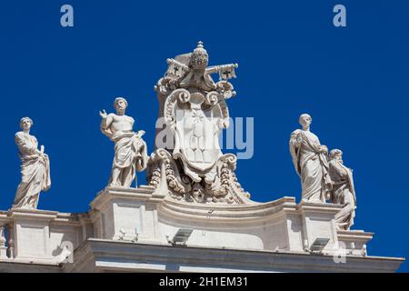 Detail der Chigi Wappen und die Statuen der Heiligen, die Krone der Kolonnaden von St. Peter Platz 1667 auf den Vatikan Stadt gebaut Stockfoto