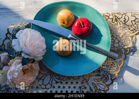 Blick von oben auf konzeptuelle Schnitt schöne gefälschte Früchte mit Messer und Blumendekor Stockfoto
