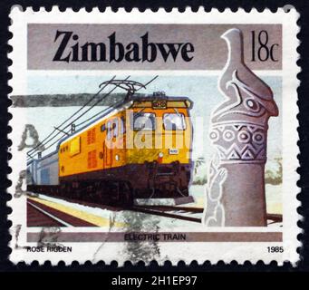 SIMBABWE - UM 1985: Eine in Simbabwe gedruckte Marke zeigt Zimbabwe Vogel- und Elektrozug, um 1985 Stockfoto