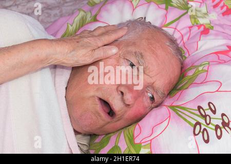 Ältere 80 plus Jahre alter Mann in einem Bett. Krankheit, Altern, ungesunde Konzepte Stockfoto