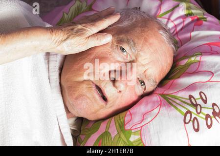 Ältere 80 plus Jahre alter Mann in einem Bett. Krankheit, Altern, ungesunde Konzepte Stockfoto