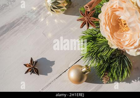 Winterferien Hintergrund mit Spiezen Blumen und goldenen weihnachtskugeln liegen auf weißem Holz Hintergrund Stockfoto