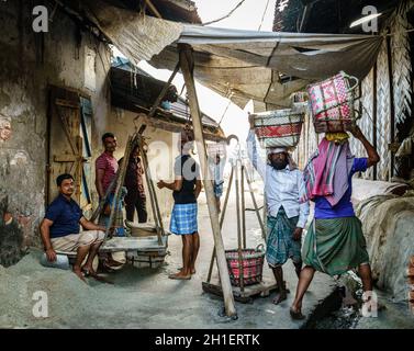 Chittagong, Bangladesch, 22. Dezember 2017: Männer wiegen Körbe mit Salz in einer Fabrik in Chittagong, Bangladesch Stockfoto