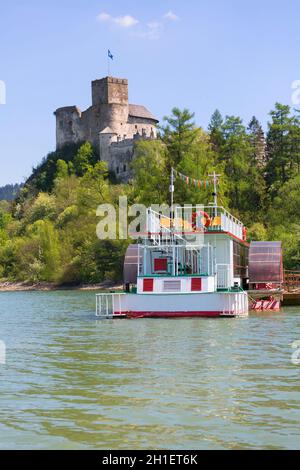 Niedzica, Polen - 18. Mai 2020: Burg Niedzica (Dunajec) aus dem 14. Jahrhundert, mittelalterliche Festung am Czorsztyn-See. Kreuzfahrtschiff am Yachthafen. Das ist es Stockfoto