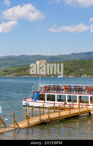 Niedzica, Polen - 18. Mai 2020: Schloss Czorsztyn aus dem 14. Jahrhundert, Riuns einer mittelalterlichen Festung am Czorsztyn-See. Kreuzfahrtschiff am Yachthafen. Stockfoto