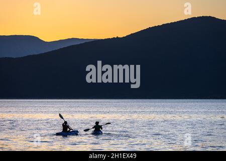 Kajakfahren auf dem Mikri Prespa See bei Sonnenuntergang in der Nähe des Dorfes Mikrolimni in Mazedonien, Nordgriechenland. Stockfoto