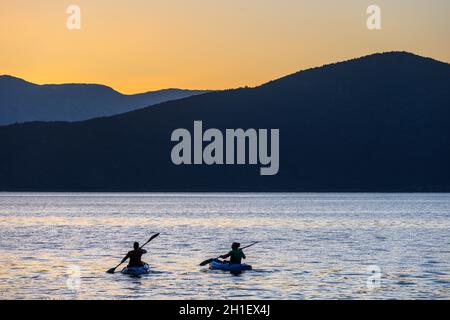 Kajakfahren auf dem Mikri Prespa See bei Sonnenuntergang in der Nähe des Dorfes Mikrolimni in Mazedonien, Nordgriechenland. Stockfoto