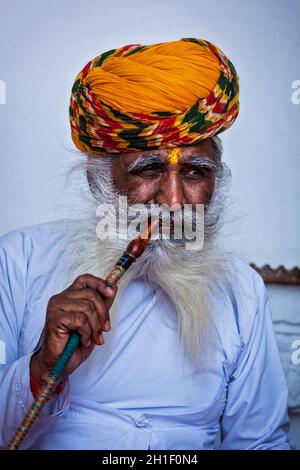 JODHPUR, INDIEN - 26. NOVEMBER 2012: Alter Inder raucht Shisha (Wasserpfeife) in der Festung Mehrangarh. Das Konzept der Shisha wird angenommen, dass ich entstanden ist Stockfoto