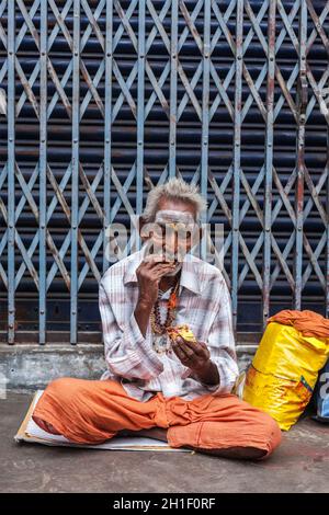 TIRUCHIRAPALLI, INDIEN - 14. FEBRUAR 2013: Nicht identifizierter alter Inder, der auf der Straße isst Stockfoto