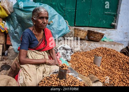 TIRUCHIRAPALLI, INDIEN - 14. FEBRUAR 2013: Unbekannte Inderin - Händler (Straßenverkäufer) von gebratenen Erdnüssen Stockfoto