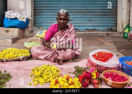 TIRUCHIRAPALLI, INDIEN - 14. FEBRUAR 2013: Unbekannte indische Frau - Händler (Straßenverkäufer) von Blumen für Tempelopfer Stockfoto