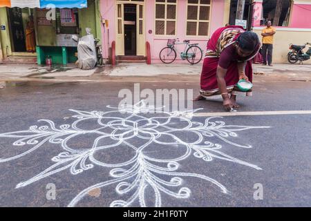 TIRUCHIRAPPALLI, INDIEN - 14. FEBRUAR 2013: Nicht identifiziertes Indien Frau Zeichnung Kolam (Rangoli) - Form der Malerei gezeichnet durch Verwendung von Reispulver vor Stockfoto