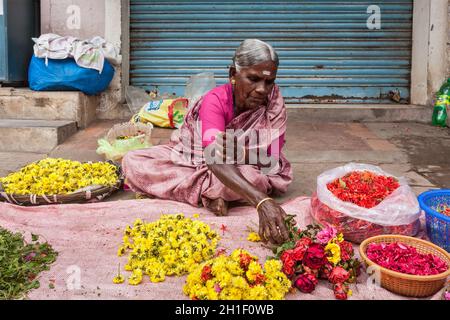 TIRUCHIRAPALLI, INDIEN - 14. FEBRUAR 2013: Unbekannte indische Frau - Händler (Straßenverkäufer) von Blumen für Tempelopfer Stockfoto