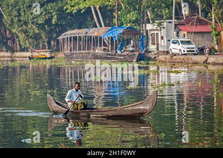 KERALA, INDIEN - 5. MAI 2010: Nicht identifizierter indischer Mann in einem kleinen Boot in Backwaters. Kerala Backwaters sind sowohl große Touristenattraktion als auch integraler Par Stockfoto