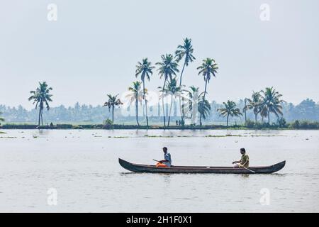 KERALA, INDIEN - 5. MAI 2010: Nicht identifizierte indische Männer in einem kleinen Boot in Backwaters. Kerala Backwaters sind sowohl große Touristenattraktion als auch integraler Par Stockfoto