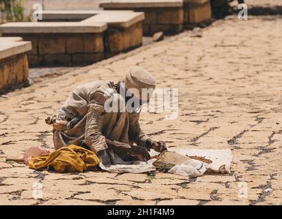 AXUM, ÄTHIOPIEN, 27. APRIL 2019: Alte Frau auf der Straße in heißen sonnigen Tag verkaufen Weihrauch hinter berühmten Kirche unserer Lieben Frau von Zion am 27. April 2019 in A Stockfoto