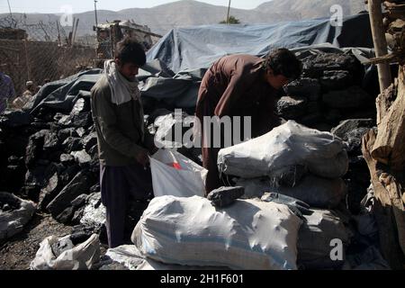 Kabul, Afghanistan. Oktober 2021. Afghanische Männer arbeiten auf einem Kohlemarkt in Kabul, Afghanistan, 17. Oktober 2021. UM MIT „Feature: Afghanen kämpfen darum, im kommenden Winter bei einer Preiserhöhung des täglichen Bedarfs warm zu bleiben“ zu GEHEN. Quelle: Saifurahman Safi/Xinhua/Alamy Live News Stockfoto