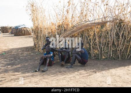 Omorate, Omo Valley, Äthiopien - 11. Mai 2019: Jugendliche aus dem afrikanischen Stamm Dasanesh kümmern sich um Frisur. Daasanach sind die ethnischen Gruppen der Cushiten Stockfoto