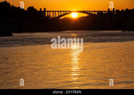 Wunderschöner oranger Sonnenuntergang über dem Fluss Duoro in Porto City Stockfoto