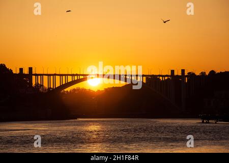 Wunderschöner oranger Sonnenuntergang über dem Fluss Duoro in Porto City Stockfoto