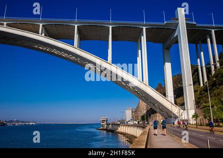 Porto, PORTUGAL - MAI 2018: Touristen und Einheimische, die einen schönen frühen Frühlingstag neben dem Fluss Douro und der Arrabida-Brücke in Porto City i genießen Stockfoto