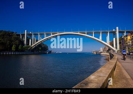 Porto, PORTUGAL - MAI 2018: Touristen und Einheimische, die einen schönen frühen Frühlingstag neben dem Fluss Douro und der Arrabida-Brücke in Porto City i genießen Stockfoto