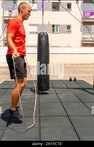 Seilspringen. Junger Sportler, der im Freien trainiert und trainiert. Sport, Fitness, Street Workout Konzept. Stockfoto