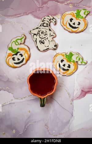 Halloween Kreativkonzept: Kürbisbecher und hausgemachte Kekse in Form von niedlichen Kürbissen und GeisterNahaufnahme. Ästhetische Herbststimmung oder Trick or Treat Konz Stockfoto