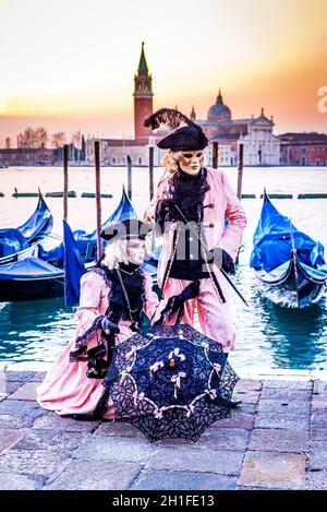 Venedig, Italien, venezianisches Maskenmodell aus dem Karneval von Venedig, mit Gondeln im Hintergrund, Canal Grande Stockfoto