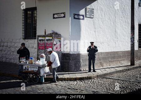 Cusco, Peru - eine Straße im Zentrum von Cusco mit alten kolonialen Architektur, gepflasterten Straßen, und einige Leute entlang eine Eis Verkäufer. Stockfoto